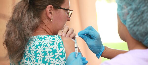 Медработник делает прививку женщине - 俄羅斯衛星通訊社