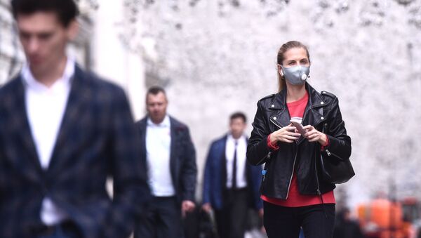 Девушка в защитной маске на Никольской улице в Москве. - 俄罗斯卫星通讯社