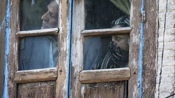 Люди смотрят из окна своего дома в Сринагаре, Индия - 俄罗斯卫星通讯社