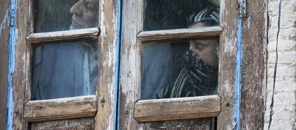 Люди смотрят из окна своего дома в Сринагаре, Индия - 俄羅斯衛星通訊社