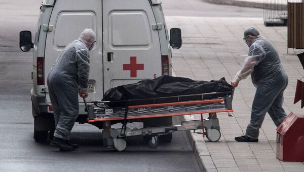 Медицинские работники перевозят тело умершего на территории карантинного центра в Коммунарке - 俄羅斯衛星通訊社