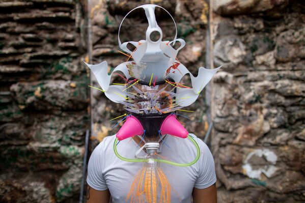 Филиппинский художник Leeroy New позирует в маске, которую он создал из переработанных материалов - 俄罗斯卫星通讯社