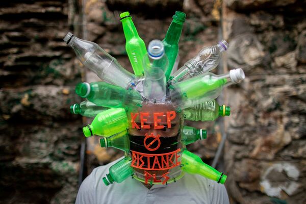 Филиппинский художник Leeroy New позирует в маске, которую он создал из переработанных материалов - 俄罗斯卫星通讯社
