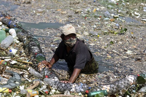 Сбор мусора, смытого дождями и удерживаемого барьером, установленным в одном из притоков озера в Аматитлане, Гватемала - 俄罗斯卫星通讯社