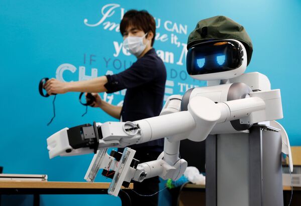 Генеральный директор Mira Robotics Кен Мацуи управляет роботом-аватаром Уго во время демонстрации в лаборатории компании в Кавасаки, Япония - 俄罗斯卫星通讯社