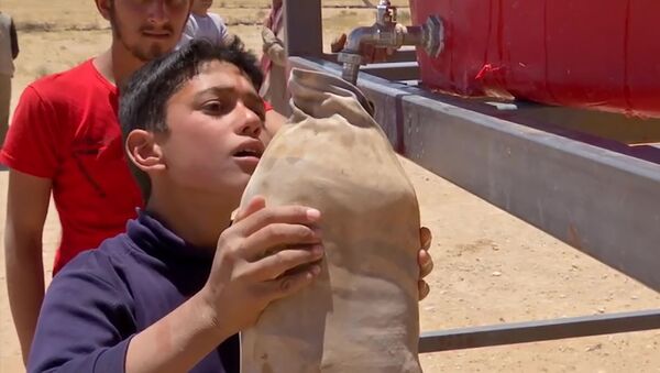 Мальчик наполняет емкость водой в военном лагере Рукбан в Сирии - 俄羅斯衛星通訊社