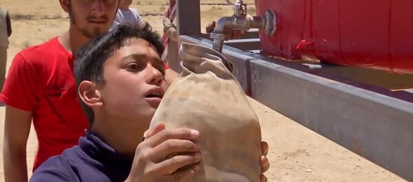 Мальчик наполняет емкость водой в военном лагере Рукбан в Сирии - 俄罗斯卫星通讯社