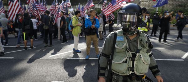 Полицейский на фоне протестующих в Гонконге Полицейский на фоне протестующих в Гонконге - 俄罗斯卫星通讯社