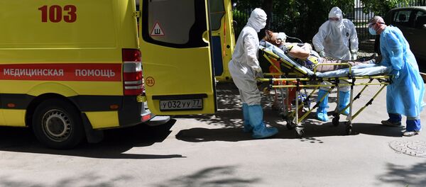 Фельдшеры и водитель перемещают пациента с подозрением на коронавирус в автомобиль скорой помощи - 俄罗斯卫星通讯社