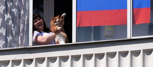 Жительница Красноярска смотрит выступление музыкального ансамбля в День России из окна своей квартиры Жительница Красноярска смотрит выступление музыкального ансамбля в День России из окна своей квартиры - 俄羅斯衛星通訊社
