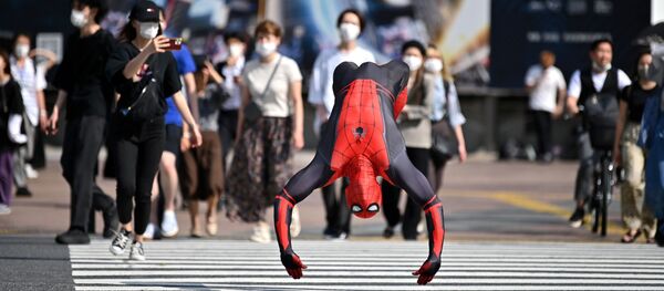 Человек в костюме Человека-паука прыгает на улице Токио - 俄罗斯卫星通讯社