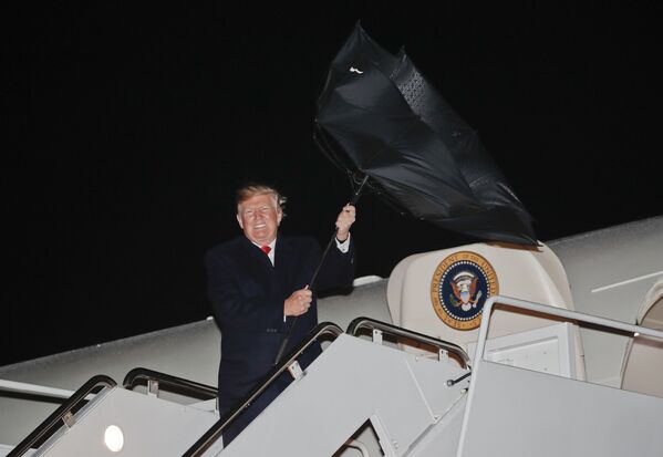 Президент США Дональд Трамп борется с зонтом в ветреную погоду - 俄罗斯卫星通讯社