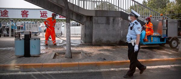 Рабочие моют территорию у закрытого рынка Синьфади в Пекине   - 俄罗斯卫星通讯社