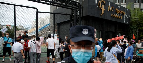 Охранник в маске пытается заблокировать камеру возле спортивного центра Guangan, где проводят тестирование на коронавирус в Пекине Охранник в маске пытается заблокировать камеру возле спортивного центра Guangan, где проводят тестирование на коронавирус в Пекине - 俄罗斯卫星通讯社
