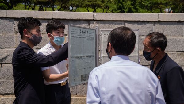 Люди читают статью, осуждающую антипхеньянские листовки, разосланные через границу южнокорейскими активистами, на новостном стенде в Пхеньяне 6 июня 2020 года. - 俄羅斯衛星通訊社