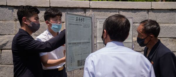 Люди читают статью, осуждающую антипхеньянские листовки, разосланные через границу южнокорейскими активистами, на новостном стенде в Пхеньяне 6 июня 2020 года. - 俄羅斯衛星通訊社