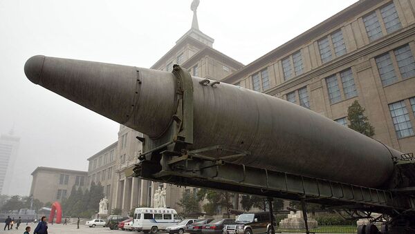 Женщина и ребенок идут к баллистической ракете малой и средней дальности, выставленной в Военном музее в Пекине. - 俄罗斯卫星通讯社