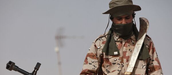 Боец с тесаком возле зенитной пушки в захваченном повстанцами городе Рас-Лануф на востоке страны. - 俄罗斯卫星通讯社