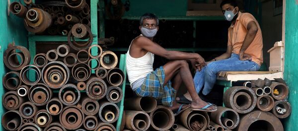 Рабочие в защитных масках в магазине, торгующем железными трубами на оптовом рынке в Калькутте, Индия - 俄罗斯卫星通讯社