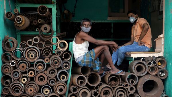 Рабочие в защитных масках в магазине, торгующем железными трубами на оптовом рынке в Калькутте, Индия - 俄羅斯衛星通訊社