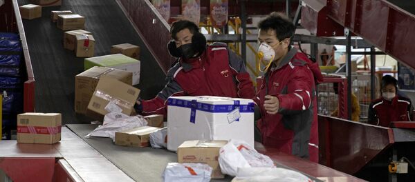 Работники службы доставки для китайского гиганта электронной коммерции JD.com сортируют посылки в распределительном центре в Пекине - 俄羅斯衛星通訊社