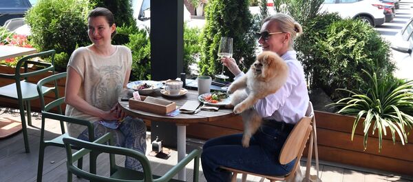 Посетители на летней веранде, расположенной на территории фудмолла Депо. Москва - 俄罗斯卫星通讯社