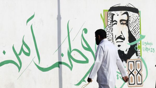 Мужчина на фоне изображения саудовского короля Салмана в Джидде. Саудовская Аравия. - 俄罗斯卫星通讯社