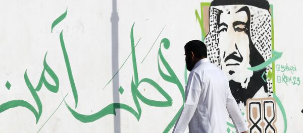 Мужчина на фоне изображения саудовского короля Салмана в Джидде. Саудовская Аравия. - 俄罗斯卫星通讯社
